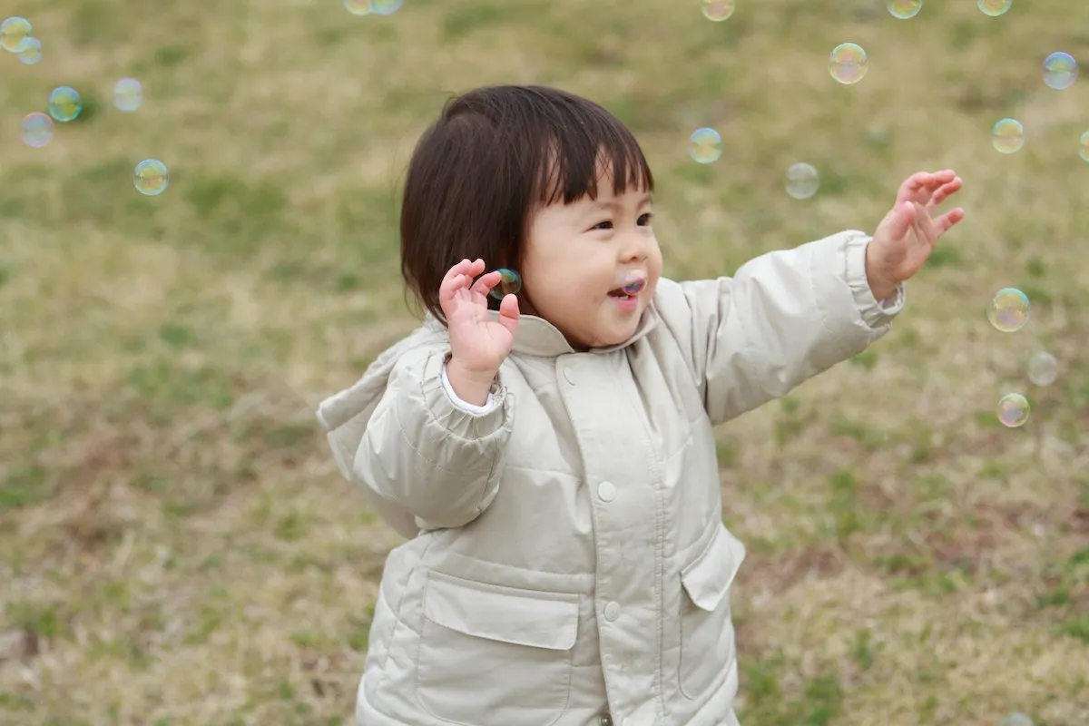 女の子がシャボン玉で遊んでいる画像